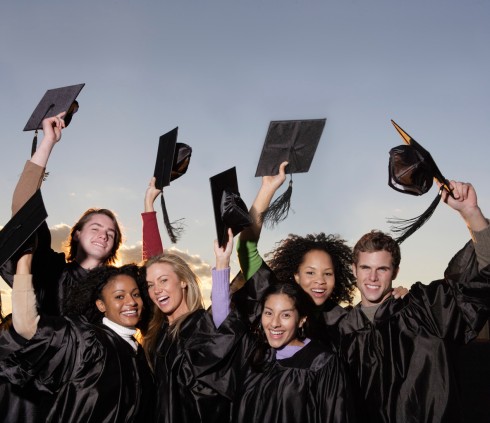 Graduates Lifting Mortarboards --- Image by © Royalty-Free/Corbis